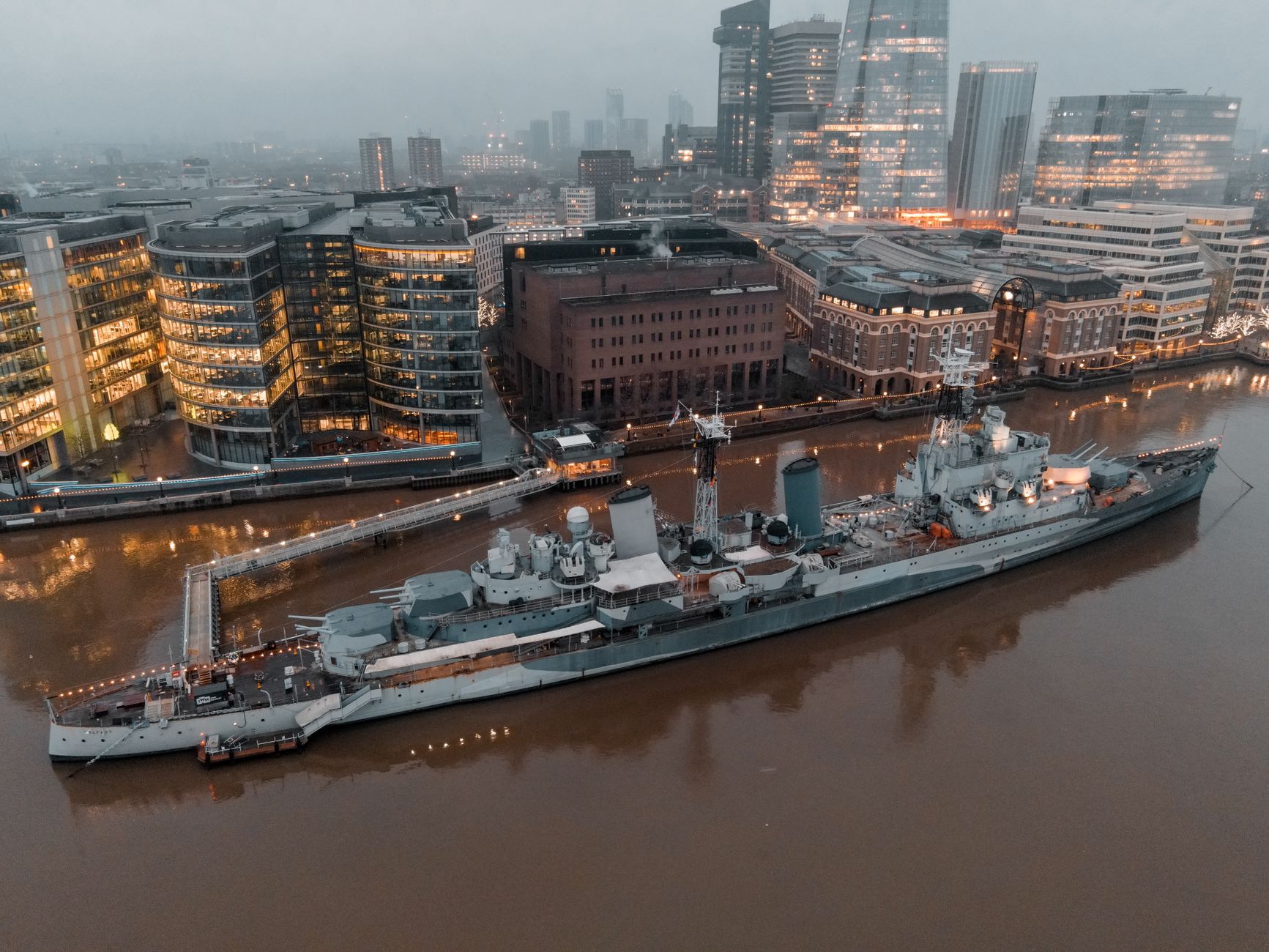 HMS Belfast na Tamizie z nocną panoramą Londynu